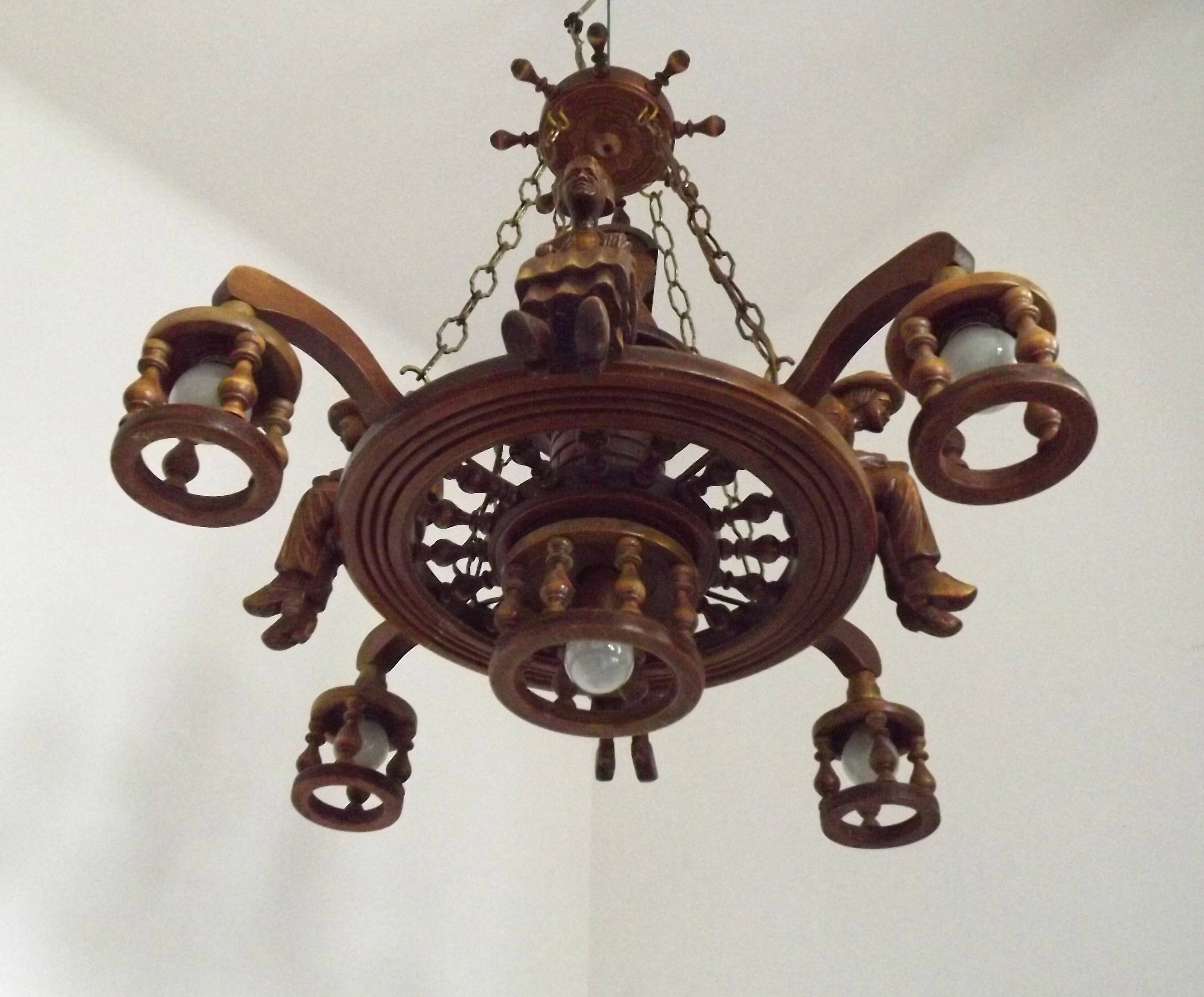 French vintage Breton chandelier with hand-carved figures, well, and lantern lights.