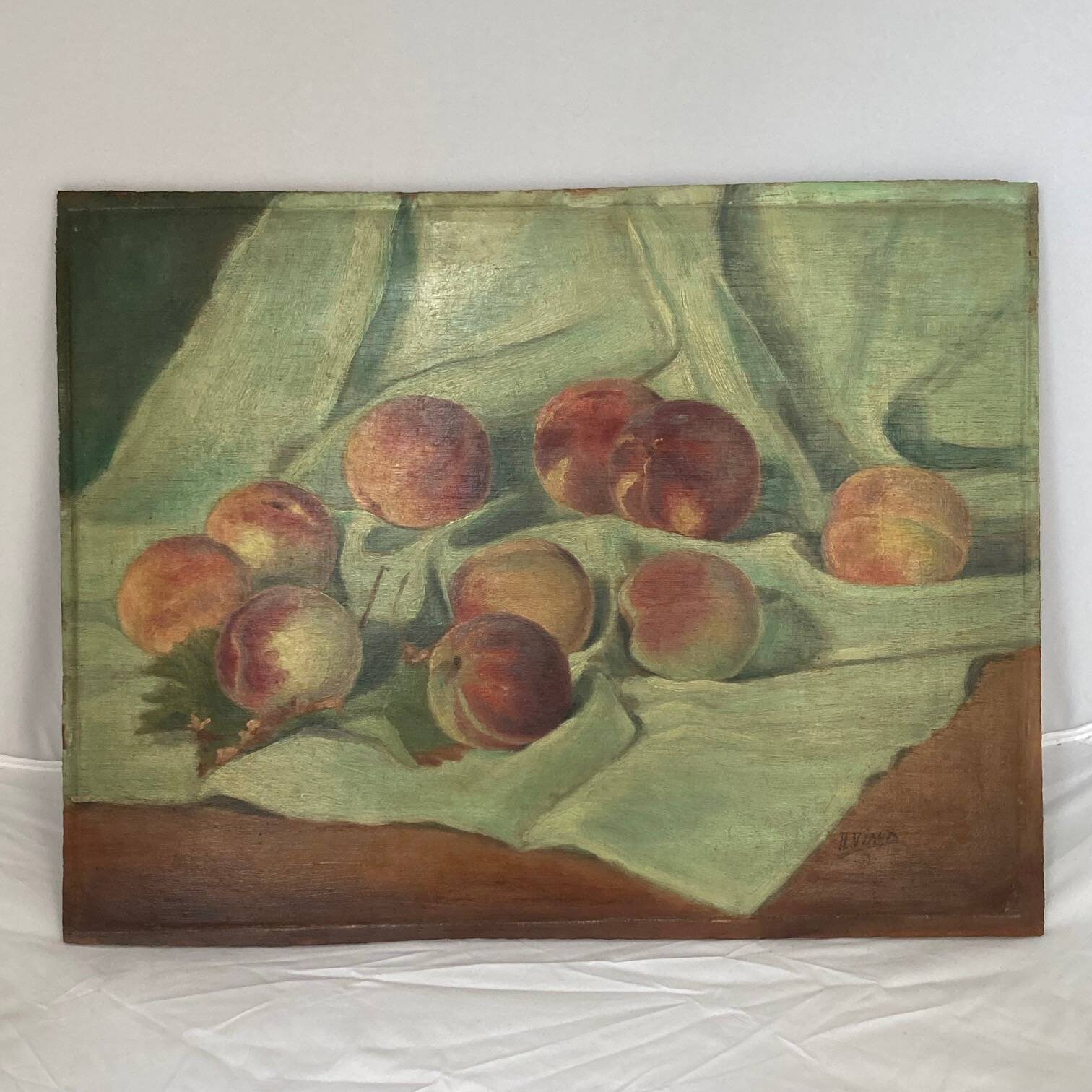 Still life depicting peaches on a cloth