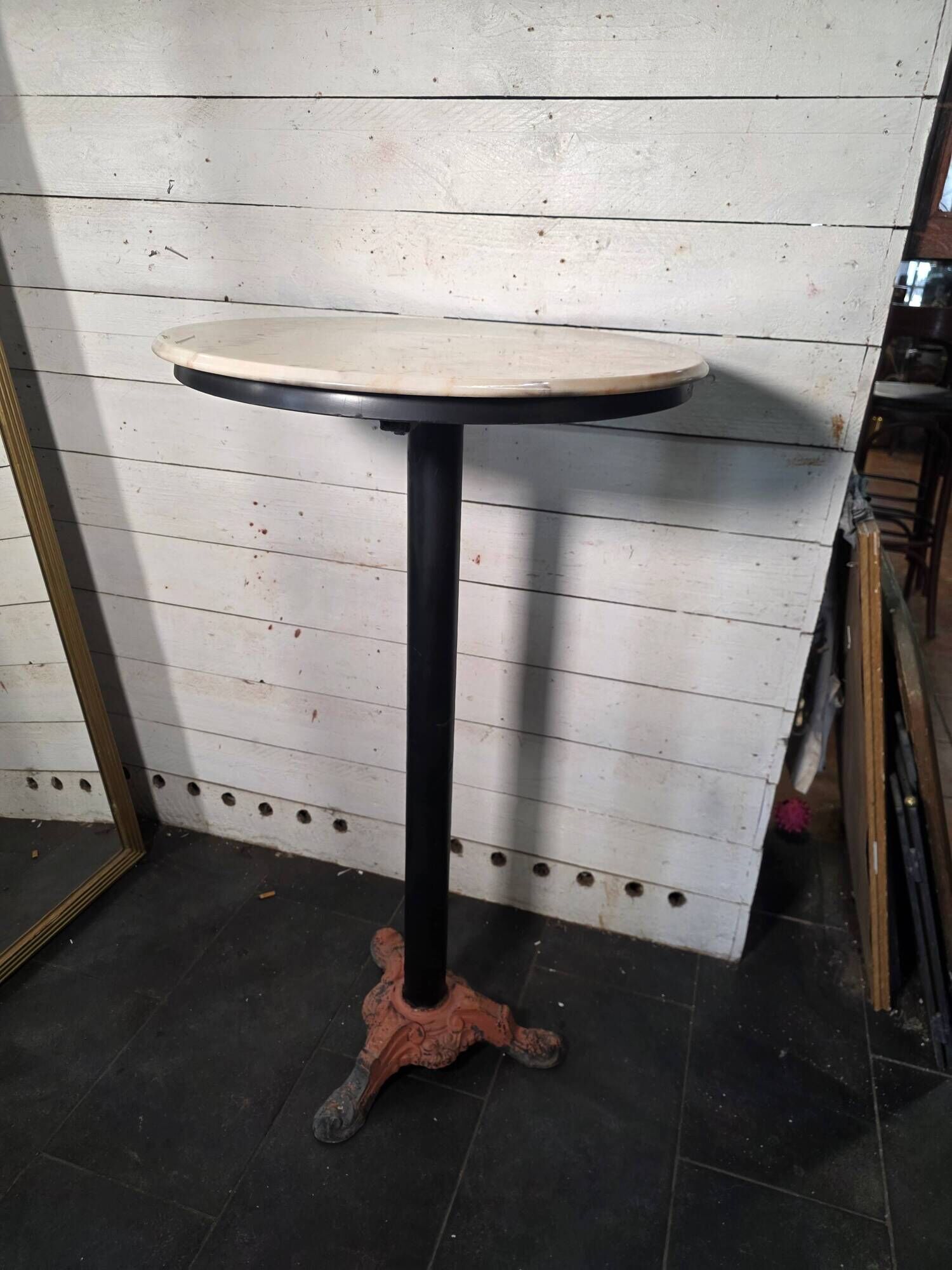 Bistro standing table with marble top and cast iron base.