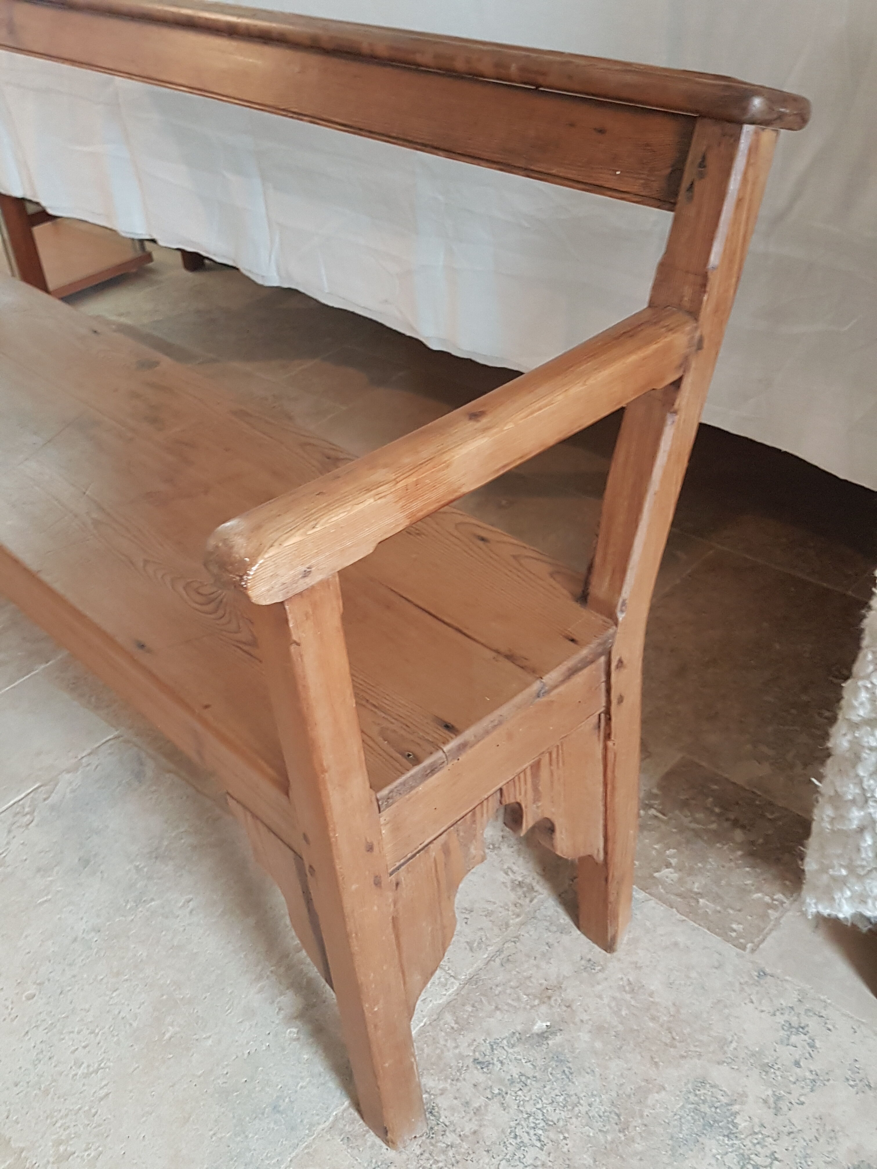 Church bench in fir tree with armrests
