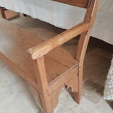 Church bench in fir tree with armrests