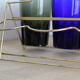 Set of 6 coloured glasses in their brass holder, basket