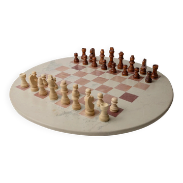 Vintage 1980s round chess set in marble, with a beige and pink marble board and wooden pieces.
