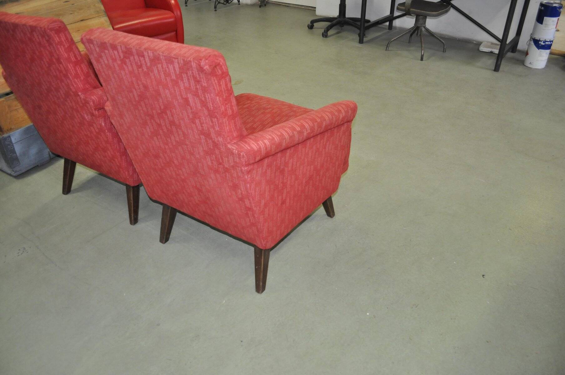 Pair of Mid-Century armchairs in red and brown fabric with dark wooden legs.