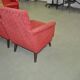 Pair of Mid-Century armchairs in red and brown fabric with dark wooden legs.