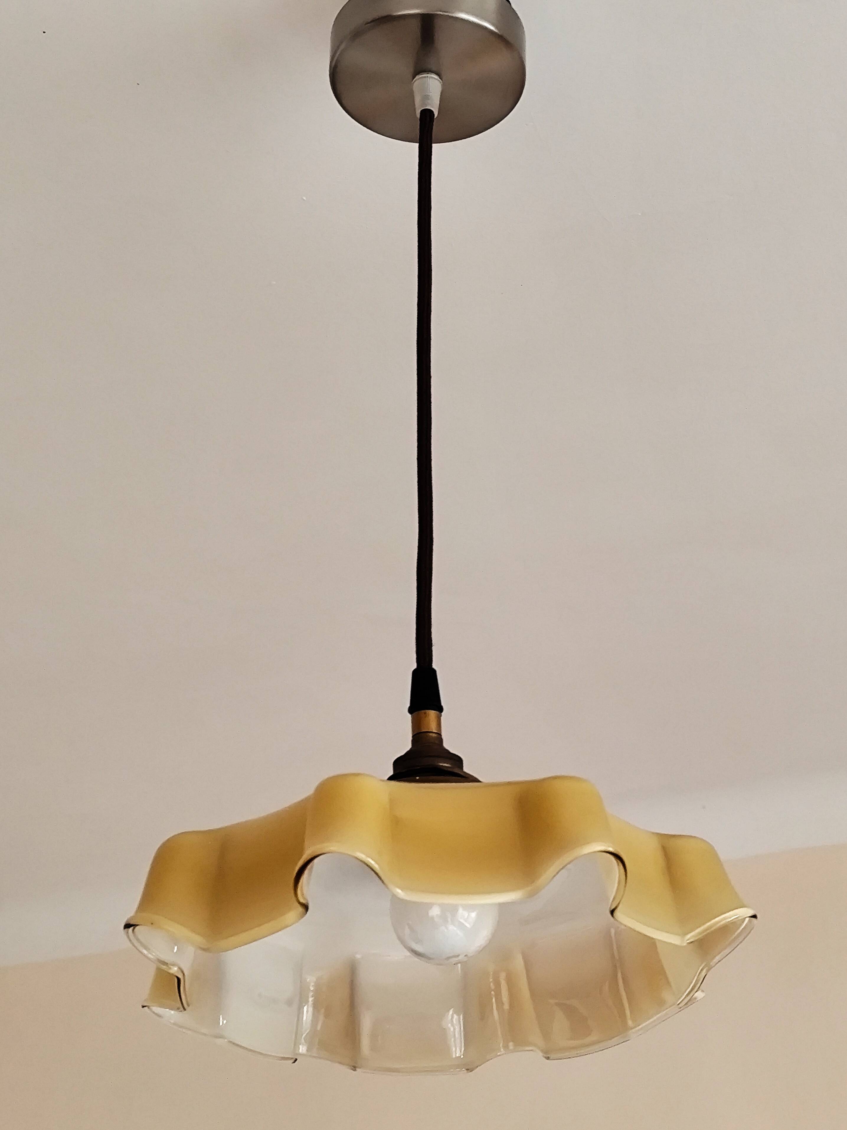 Electrified suspension with a frosted opaque glass disc shade.