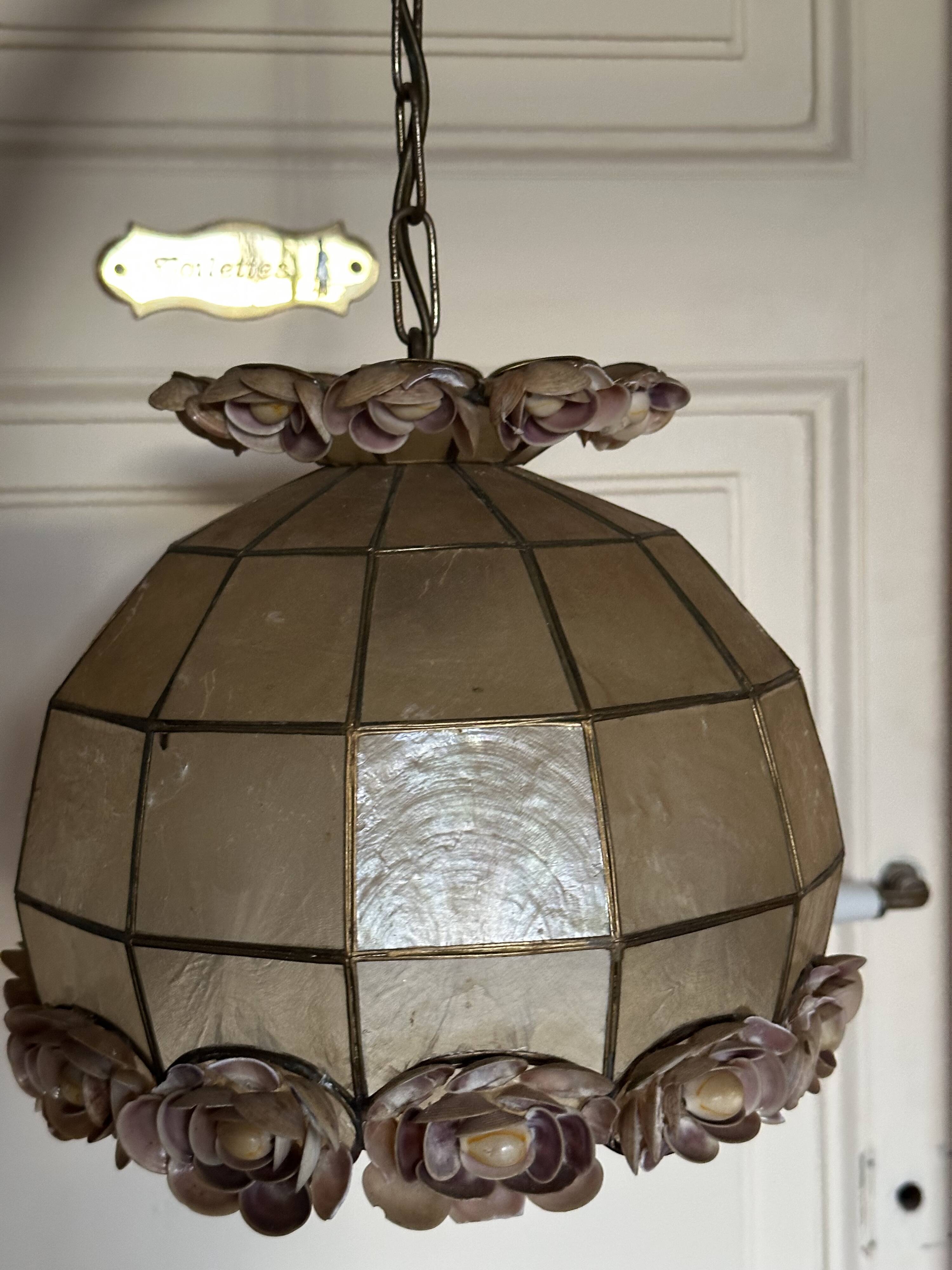 Vintage pendant light with a pearlescent shade and floral decoration.