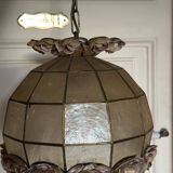 Vintage pendant light with a pearlescent shade and floral decoration.