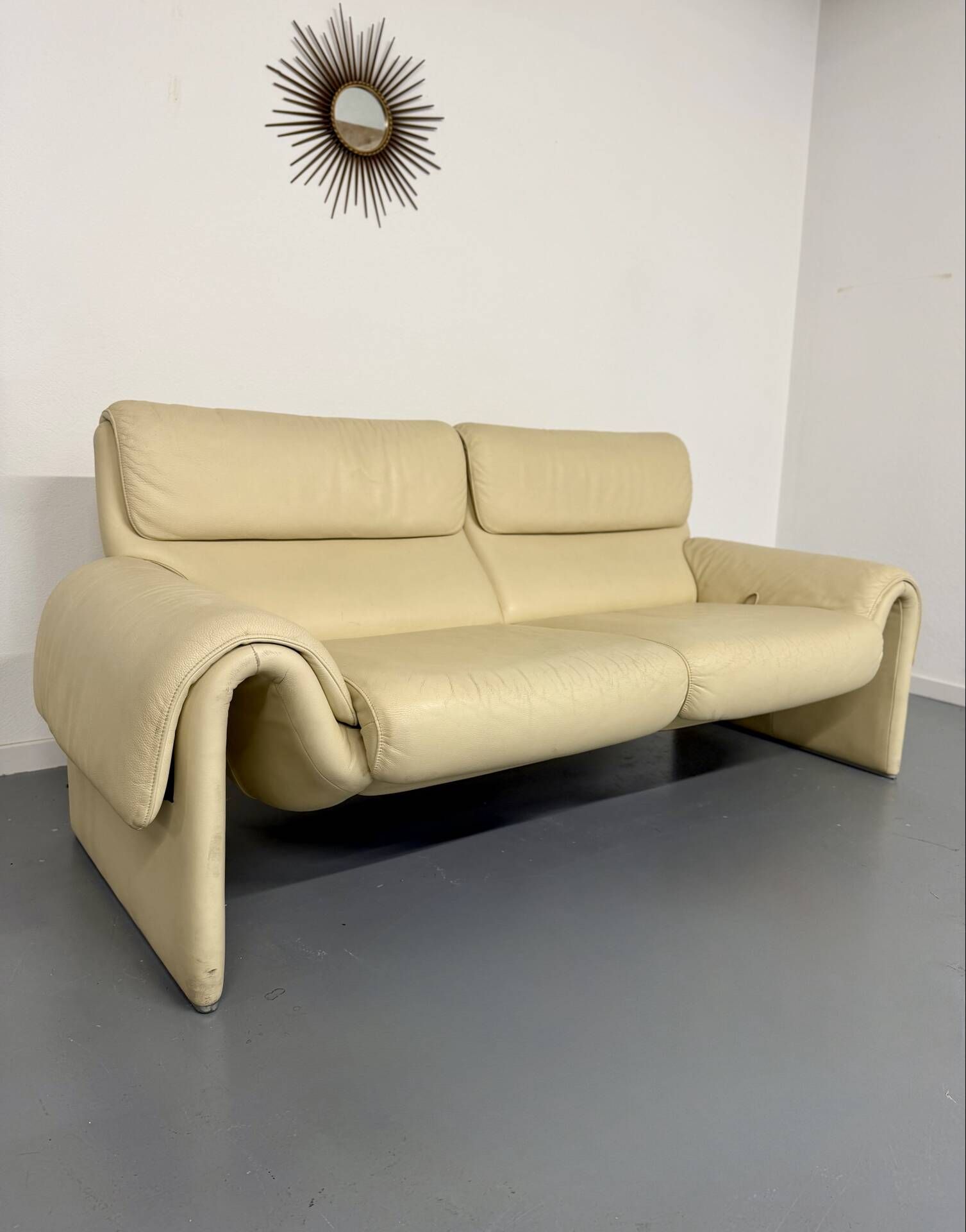 Two-seater designer sofa De Sede DS-2011 in cream leather with adjustable backrest.