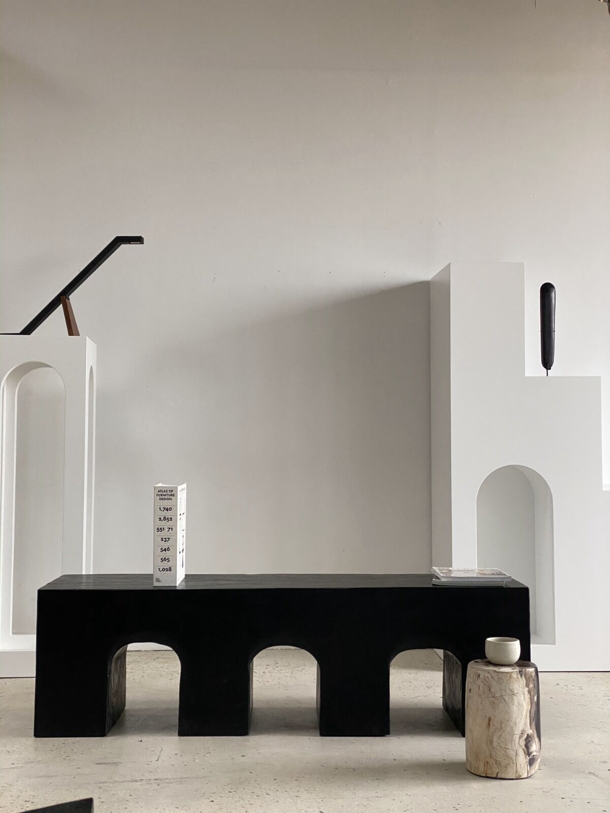 Black solid monoxyl wood bench carved into 3 arches