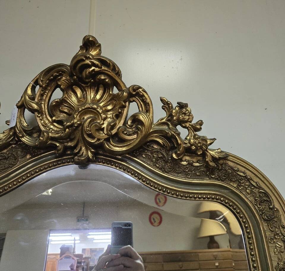 Large carved and gilded wooden mirror, rectangular in shape.