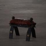 Dark red upholstered camel saddle stool, 20th century, North Africa.