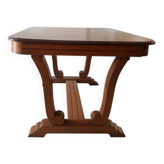 Solid wood dining table with a sculptural base.