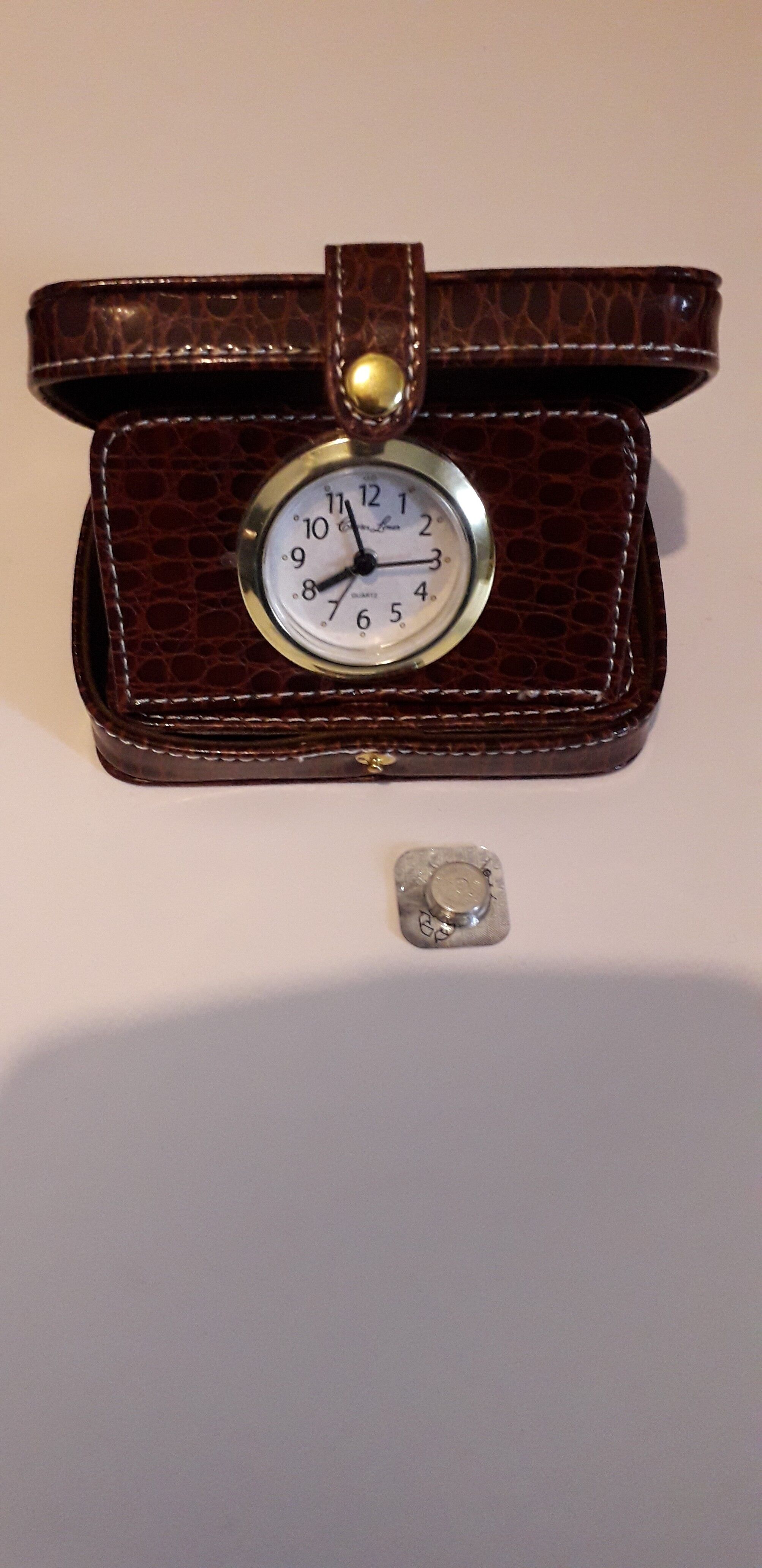 Small travel alarm clock in its case with jewelry compartments