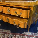 Large bow-fronted chest of drawers in blonde cherry with bronze ornamentation.