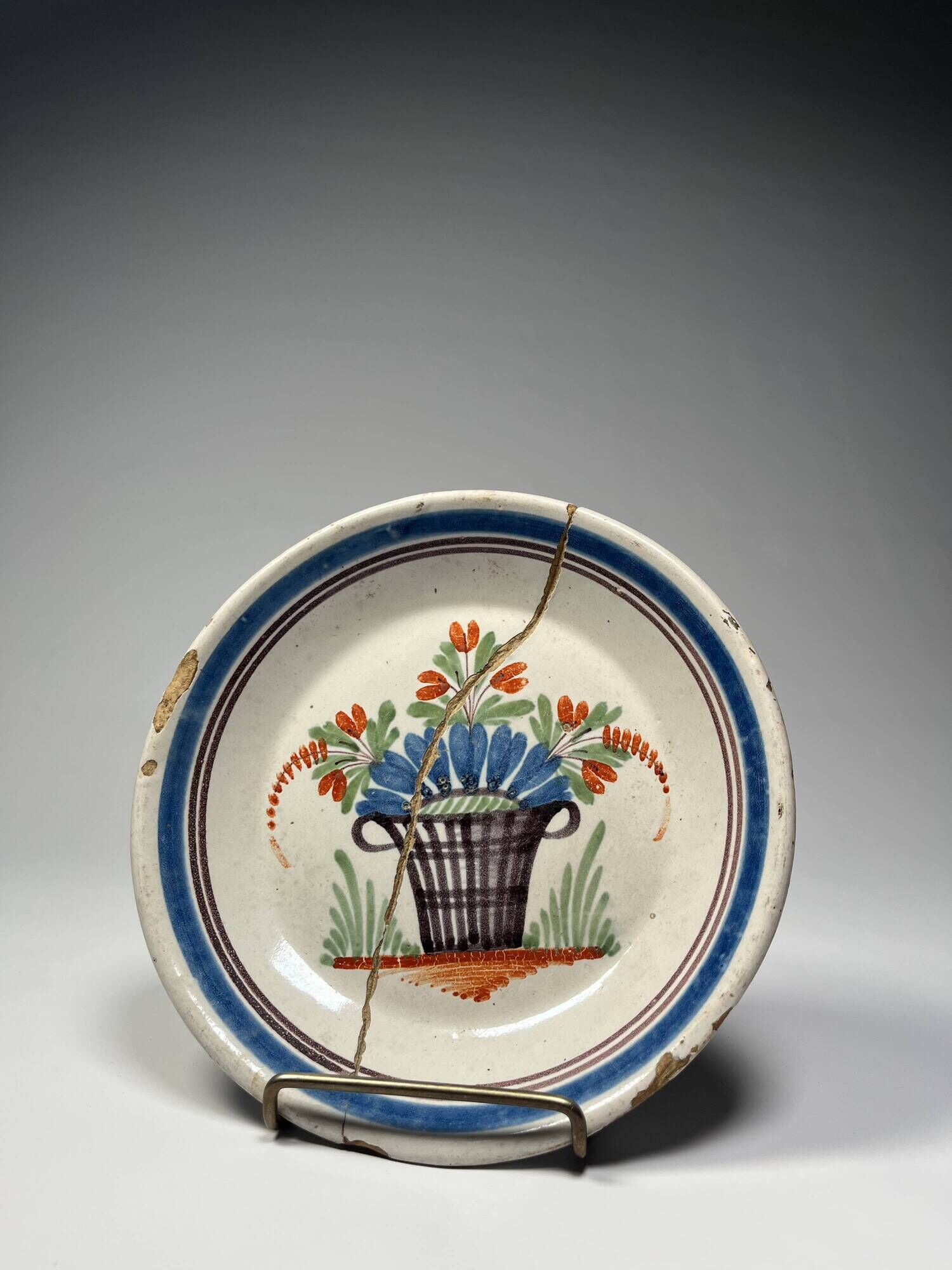 Two antique 18th-century faience plates, stapled.