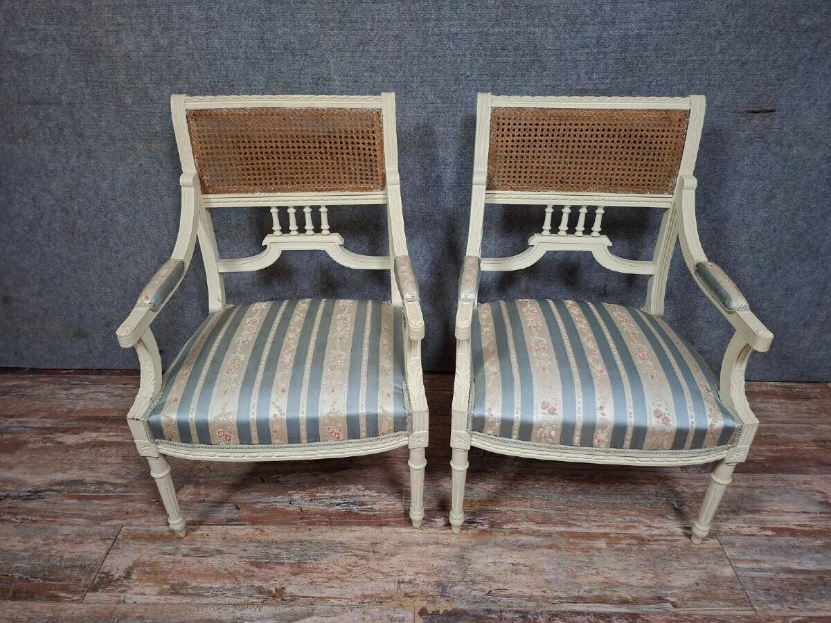 a pair of caned armchairs in the Louis XVI style, elegant and full of charm.
