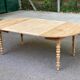 Table à manger ronde extensible à volets décapée en noyer brut 2 rallonges