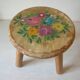 Old tripod stool with 3 wooden legs, painted floral decoration, flower bouquet