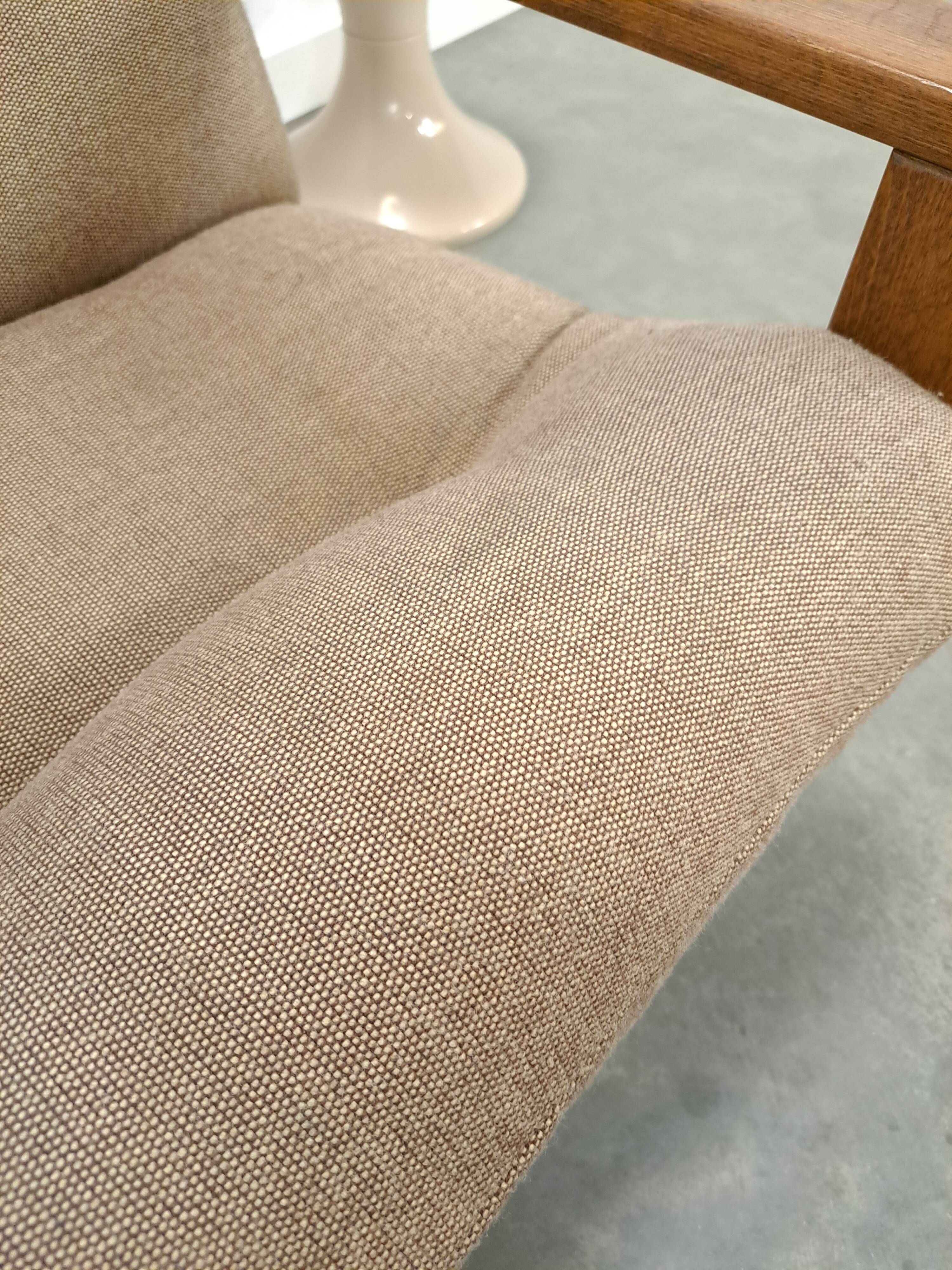 Brown-grey armchair with an oak frame.