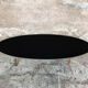 Oval coffee table with a black tray and oak-turned feet