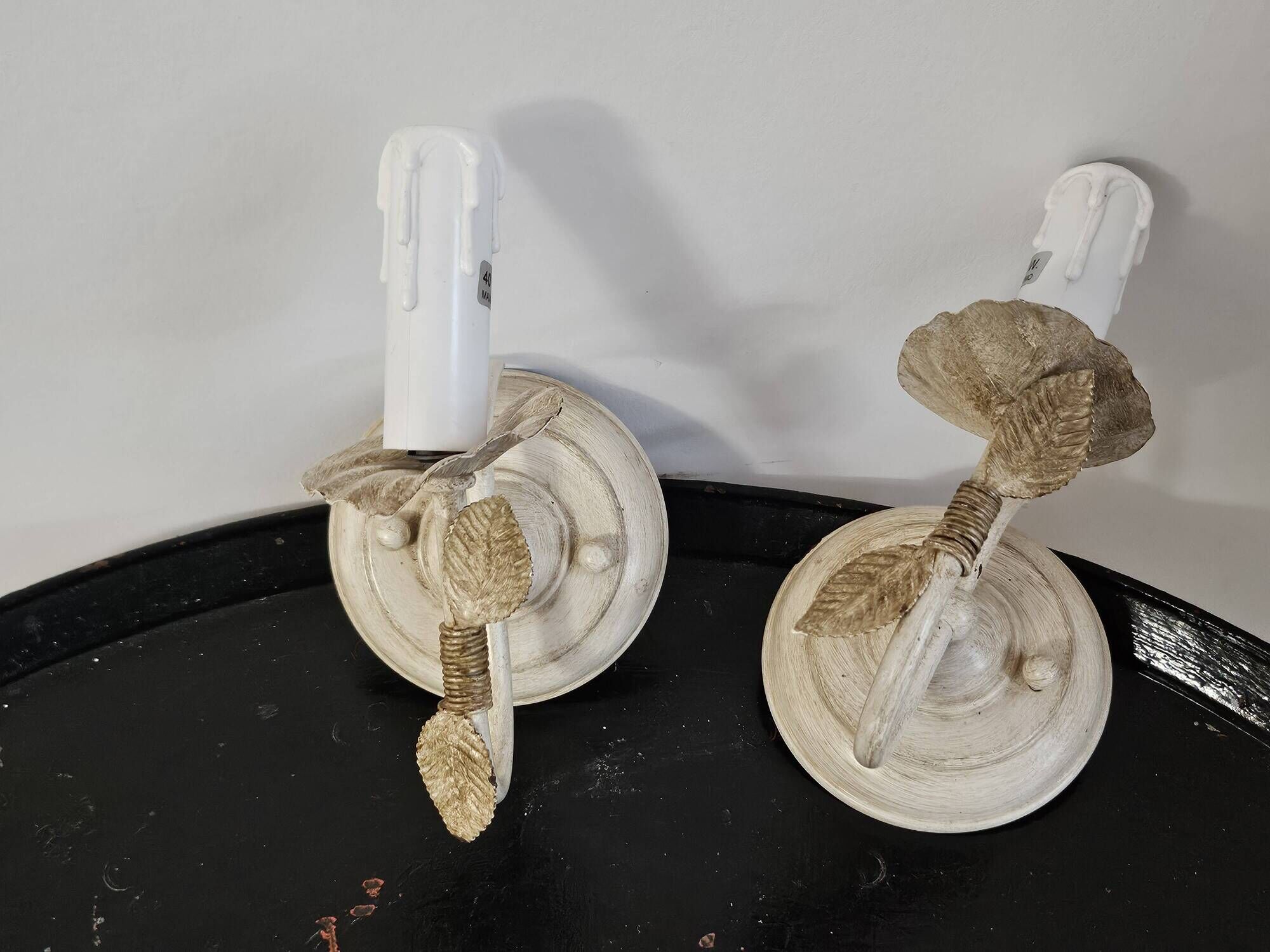 Pair of cream patinated metal wall sconces with floral decoration.