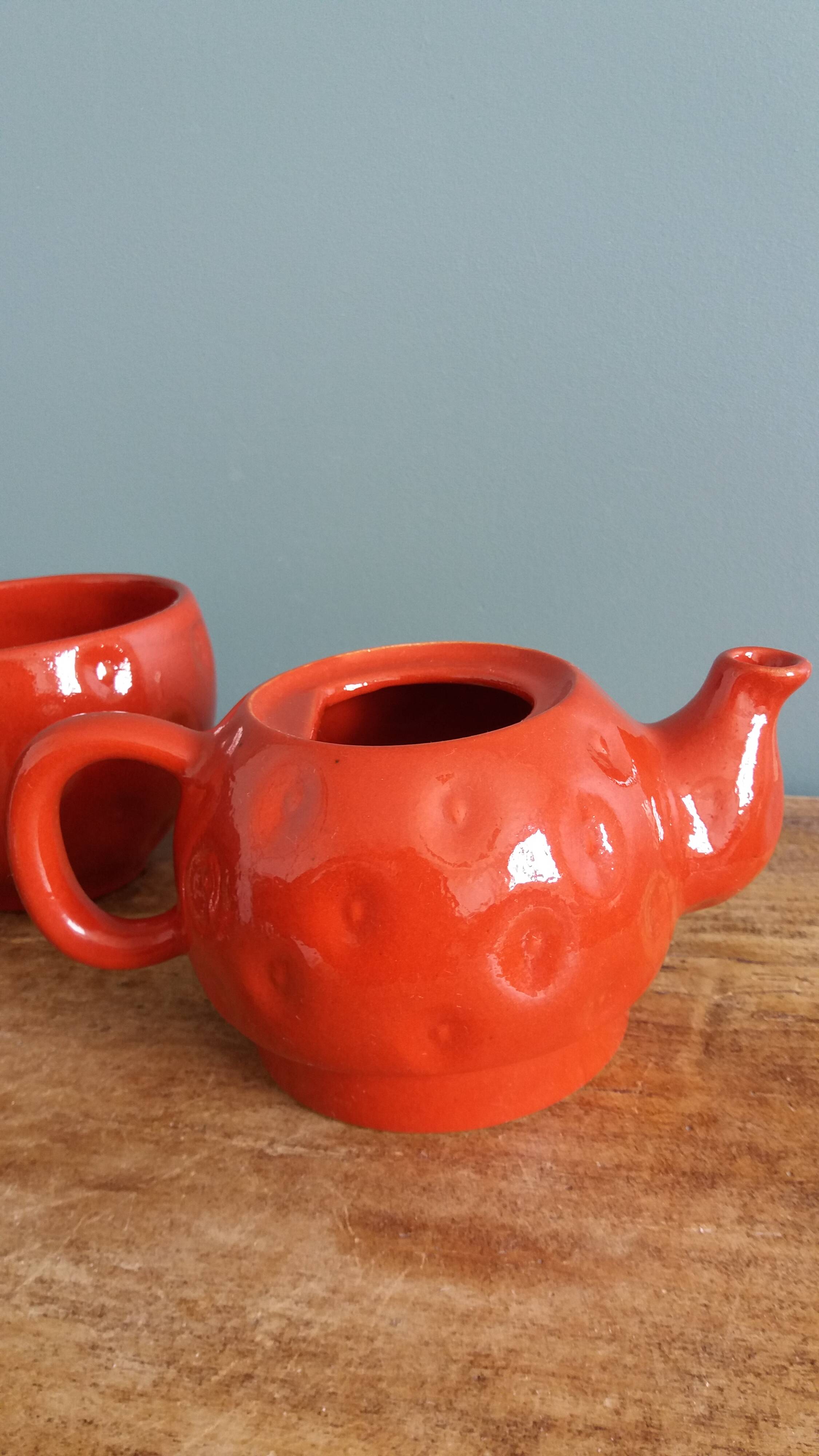 Teapot and cup in the shape of a strawberry.
