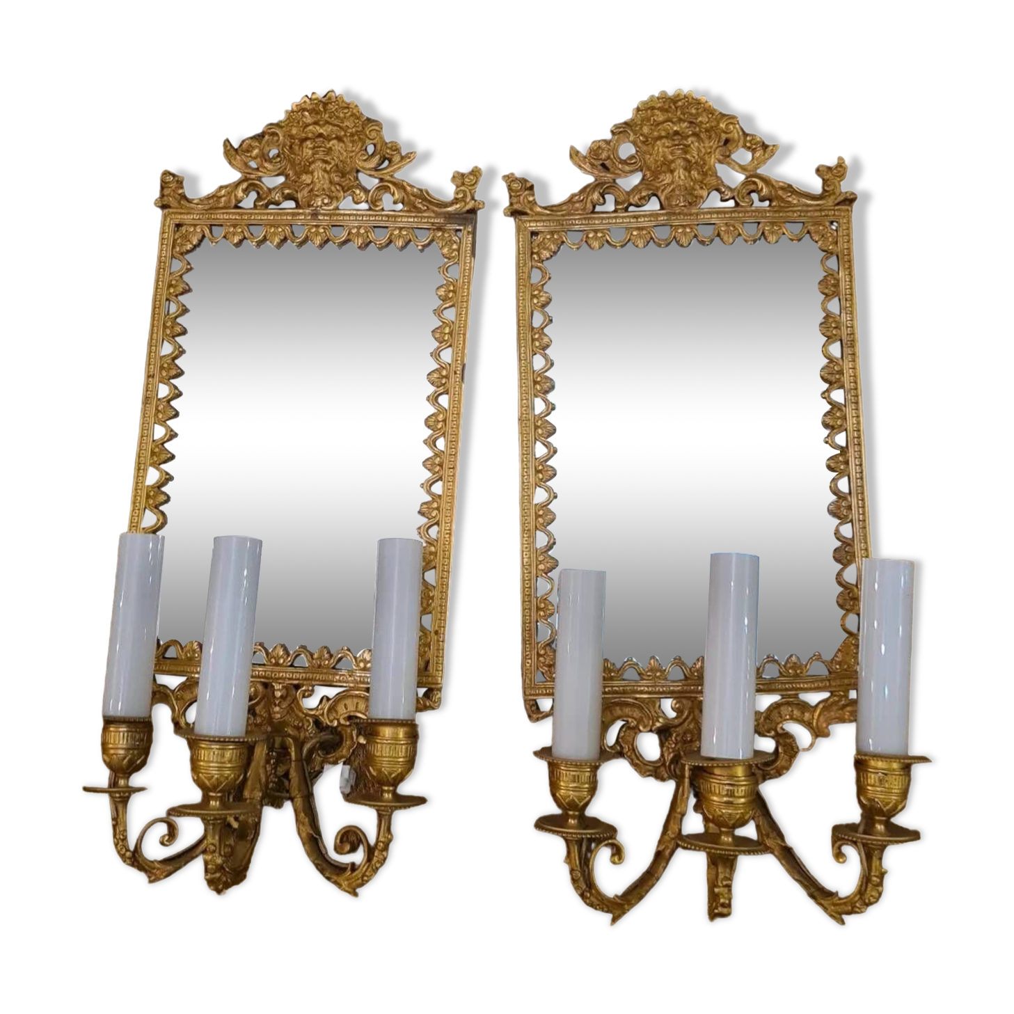 Pair of wall lights with mirror backgrounds with 3 arms of lights in chiseled and gilded bronze. framing decorated with foliage and masks. louis xiv style