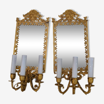 Paire d’appliques à fond de miroirs à 3 bras de lumières en bronze ciselé et doré. encadrement a décors de feuillage et mascarons. style louis xiv