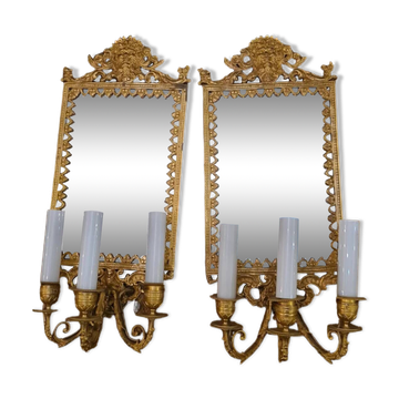 Pair of wall lights with mirror backgrounds with 3 arms of lights in chiseled and gilded bronze. framing decorated with foliage and masks. louis xiv style