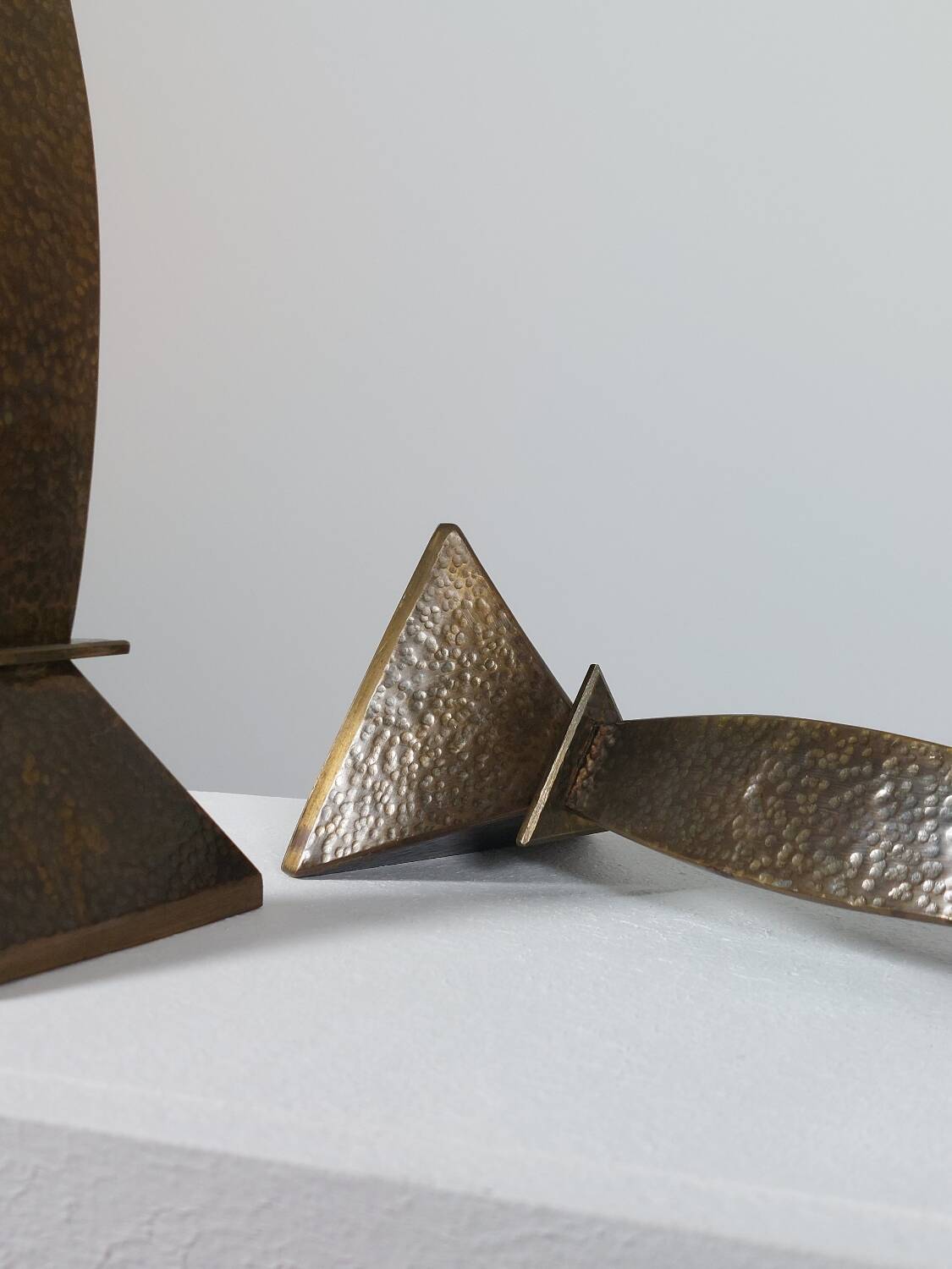 Pair of hand-hammered brass candlesticks in Memphis style.