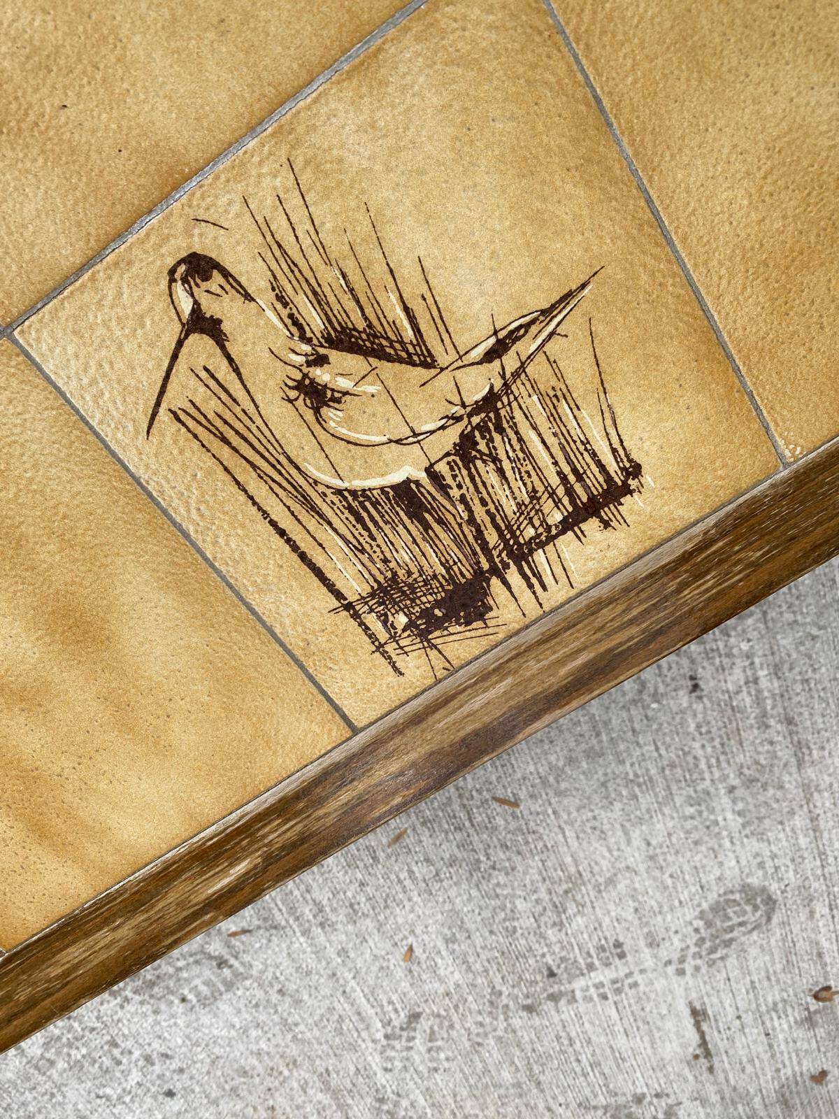 Vintage 70s coffee table with wood and ceramic tiles featuring bird and nature patterns.