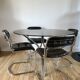 Set consisting of a table in chrome and smoked glass and its 4 tubular chairs in chrome and skaï a