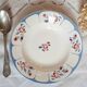 Mismatched old soup plates accompanied by a soup tureen