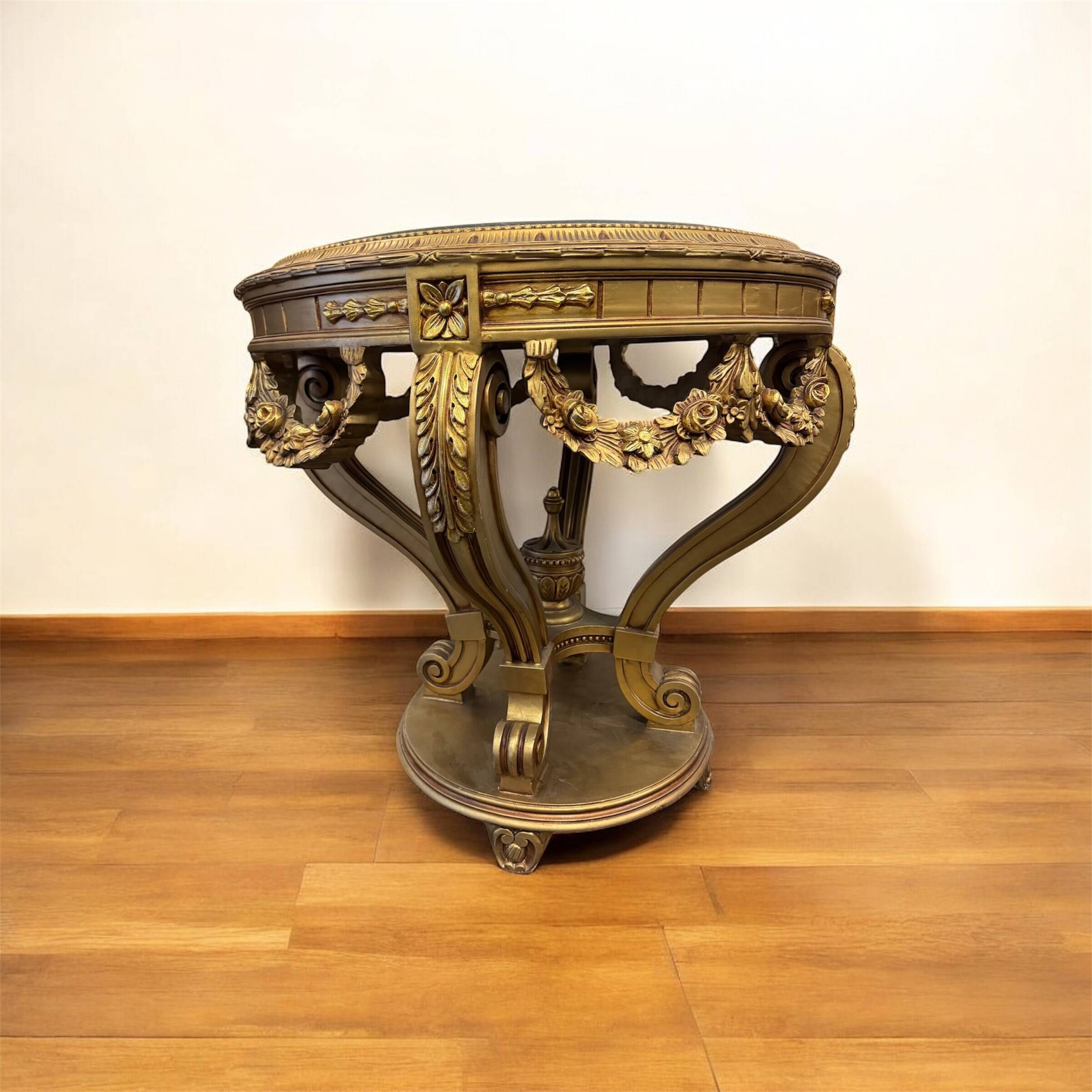A round Louis XV style table in carved gilt beechwood with a black marble top