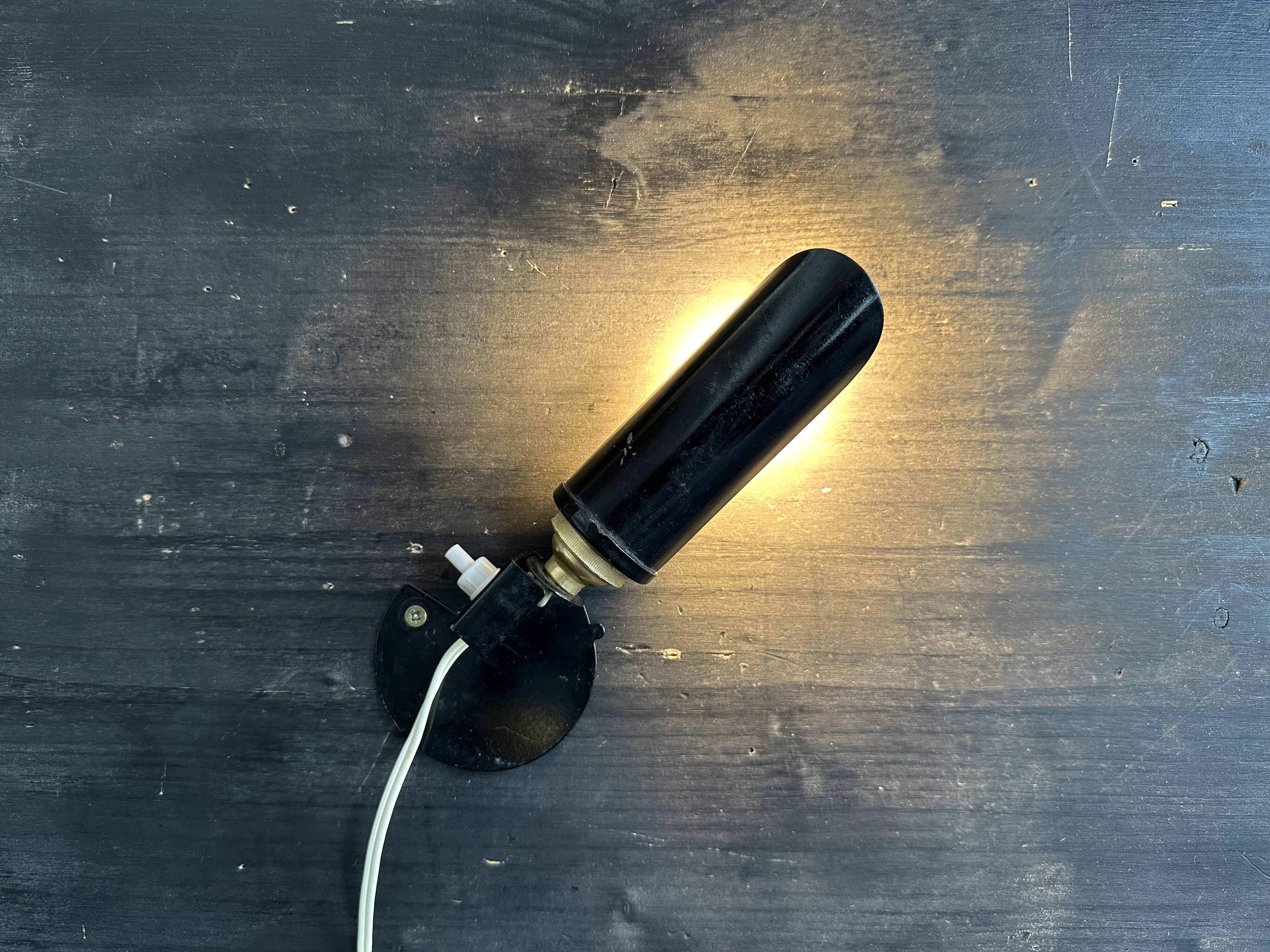 Old black metal and brass wall light, adjustable, 1930s.