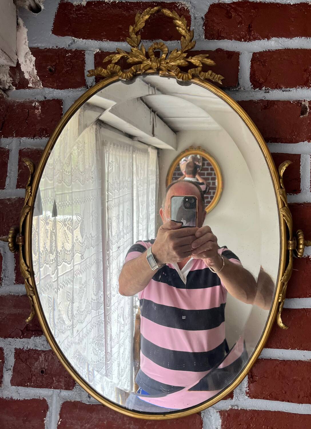 Beveled oval mirror in gilded bronze