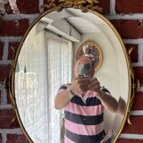 Beveled oval mirror in gilded bronze