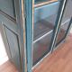 Glass-fronted cabinet in weathered green wood