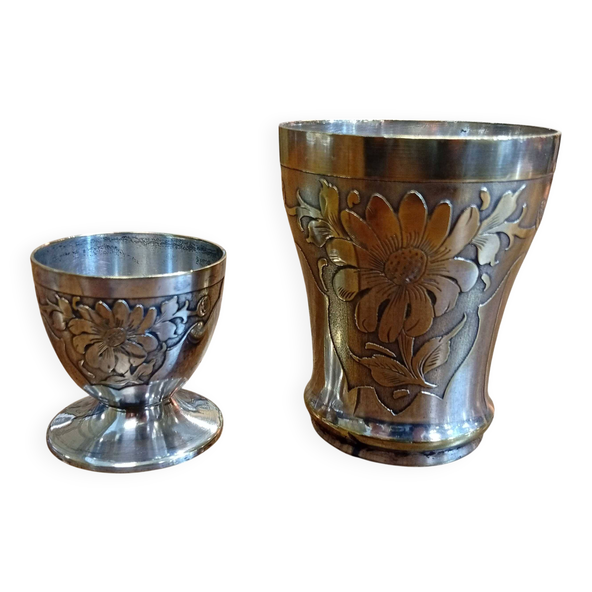 Silver-plated cup and egg cup set with floral decoration.