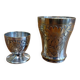 Silver-plated cup and egg cup set with floral decoration.