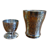 Silver-plated cup and egg cup set with floral decoration.