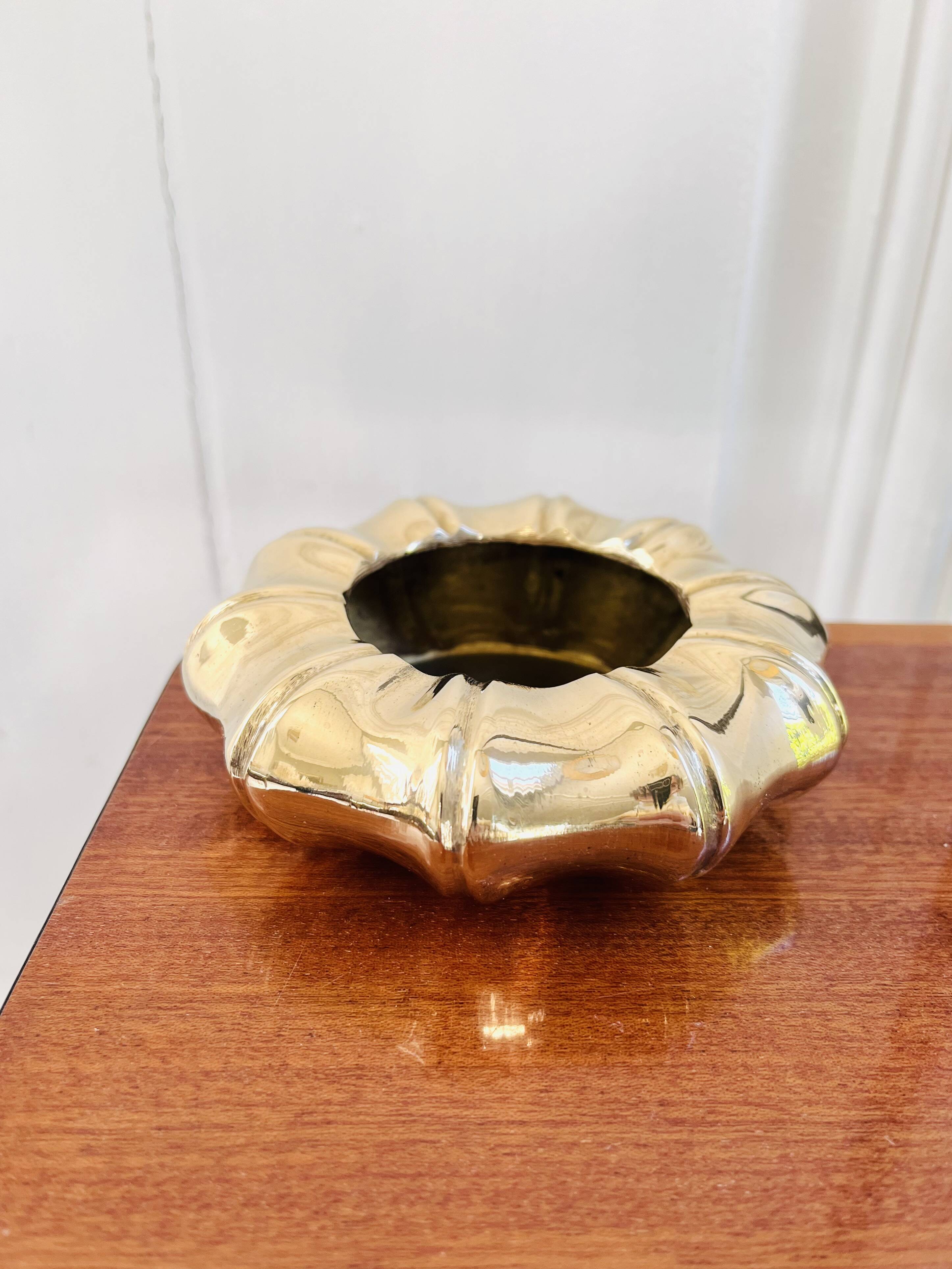 Golden brass ashtray with bamboo decoration.