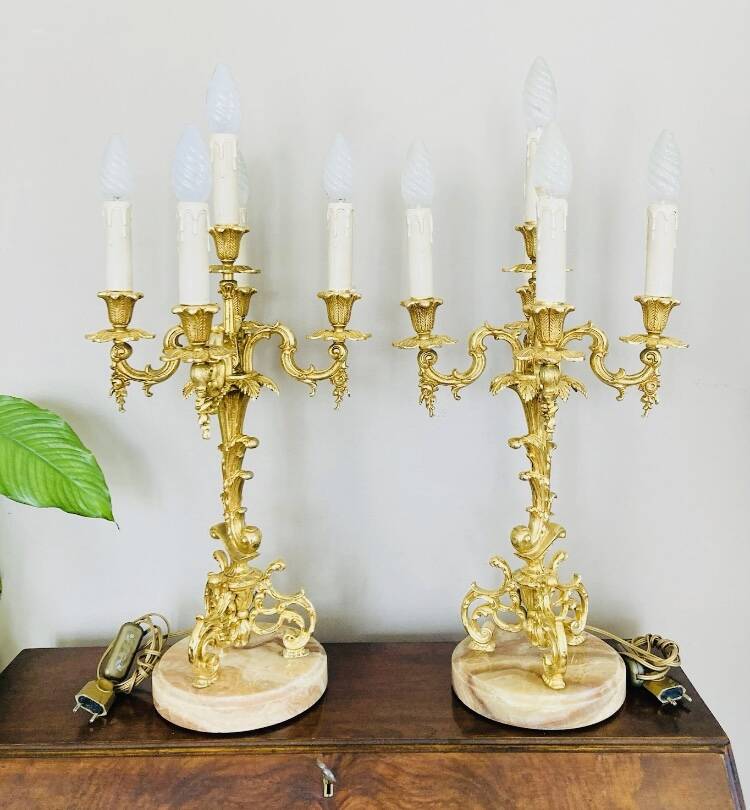 Massive gilded bronze chandeliers from the mid-20th century with marble bases.
