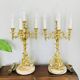Massive gilded bronze chandeliers from the mid-20th century with marble bases.