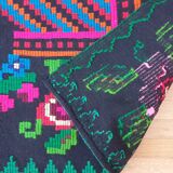 Handwoven colorful Romanian carpet, green and black background with gorgeous colorful flowers
