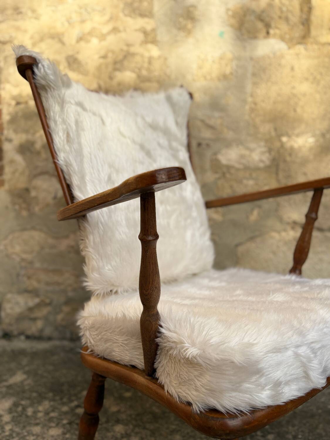 Scandinavian armchair in solid wood with beige fur cushion