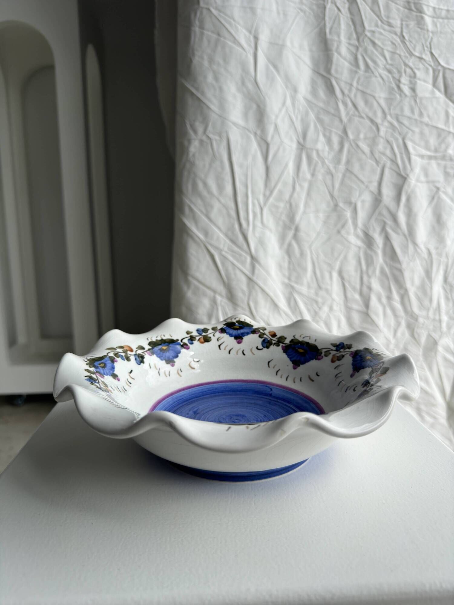 Small hand-painted earthenware salad bowl with garland of blue flowers, mark below