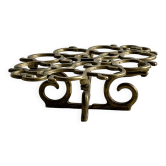 Brass trivet with openwork pattern in the shape of apples.