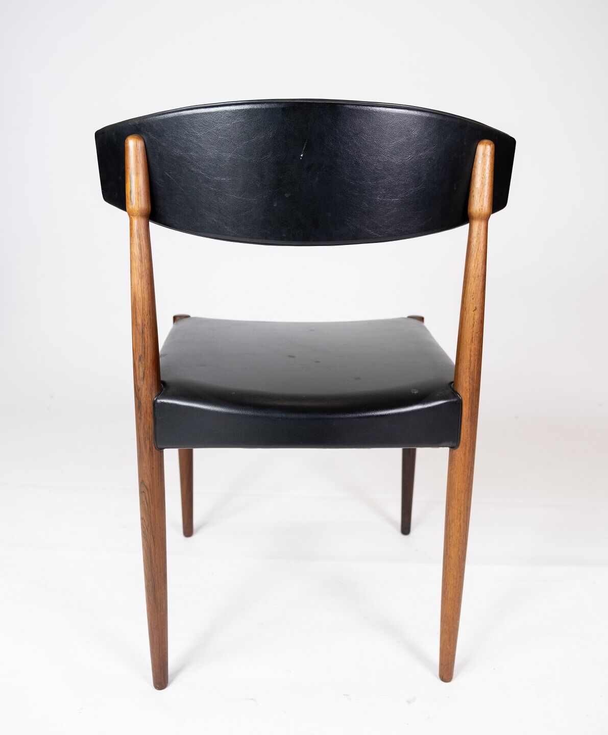 Set of four dining room chairs in rosewood and black leather of danish design from the 1960s.